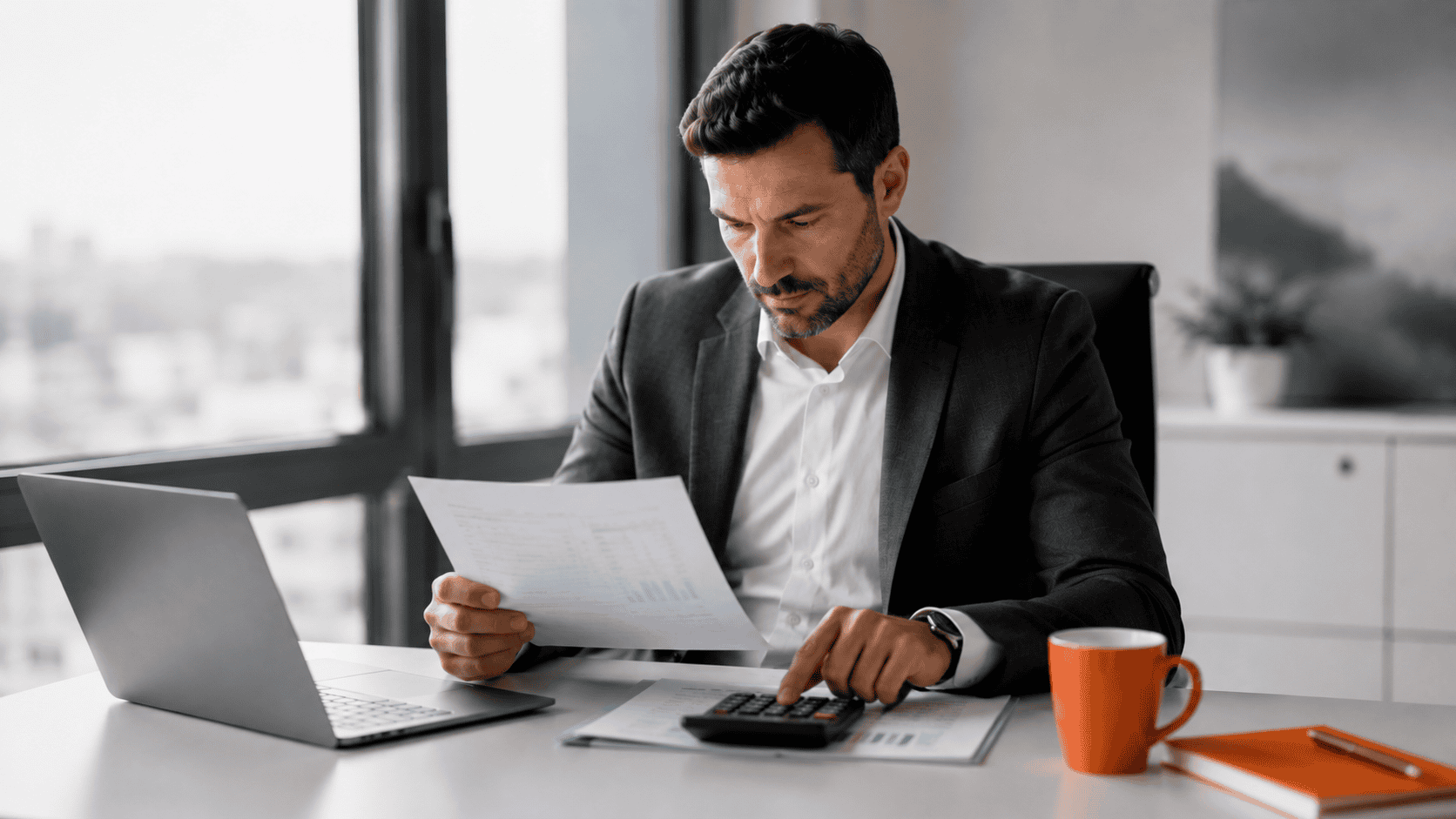 Dirigeant analysant des rapports financiers et calculant les performances de son entreprise.
