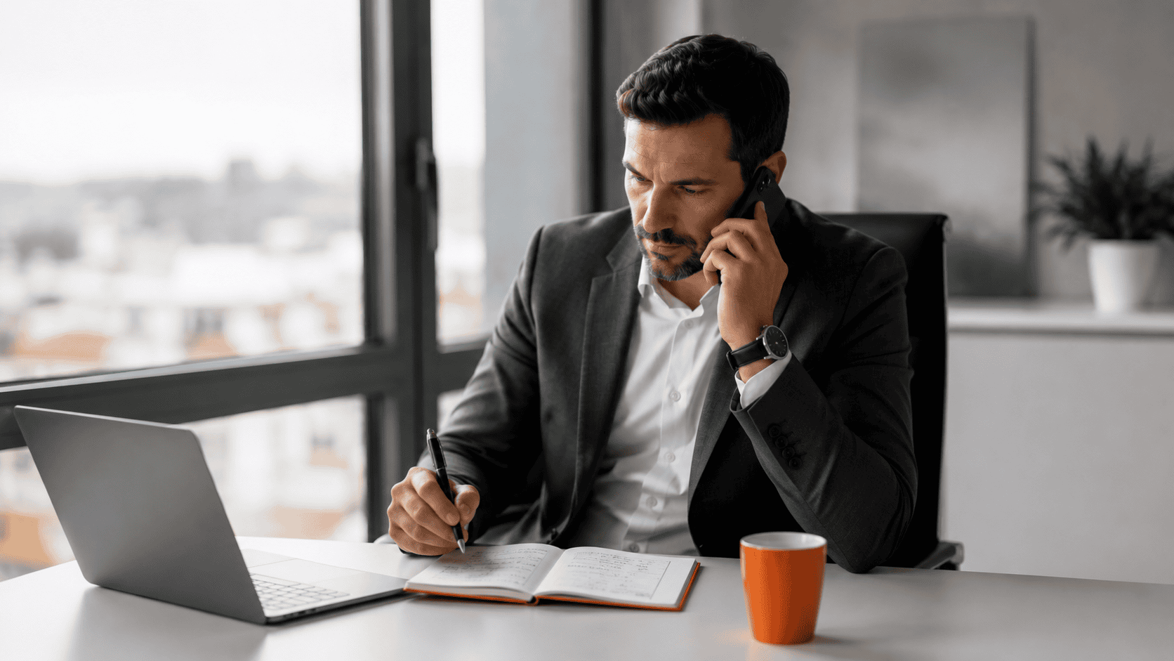 Dirigeant échangeant par téléphone tout en prenant des notes stratégiques dans un bureau moderne.